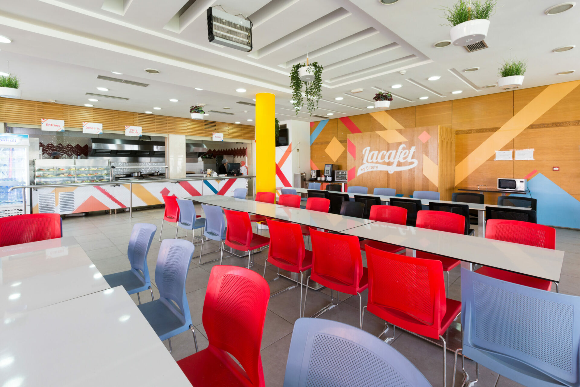 Intérieur du restaurant d'entreprise Lacafet Ompic, avec un espace de restauration spacieux, des couleurs vives et une ambiance conviviale. Conçu par l'architecte d'intérieur Anas Taleb