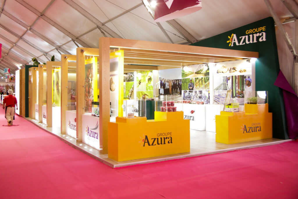 Stand d'exposition du Groupe Azura au Siam, conçu par Archigram, mettant en valeur les produits agricoles et l'engagement de l'entreprise.