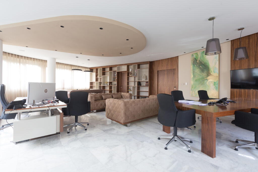 Bureau élégant avec canapés en velours capitonné, étagères murales, et table de réunion moderne