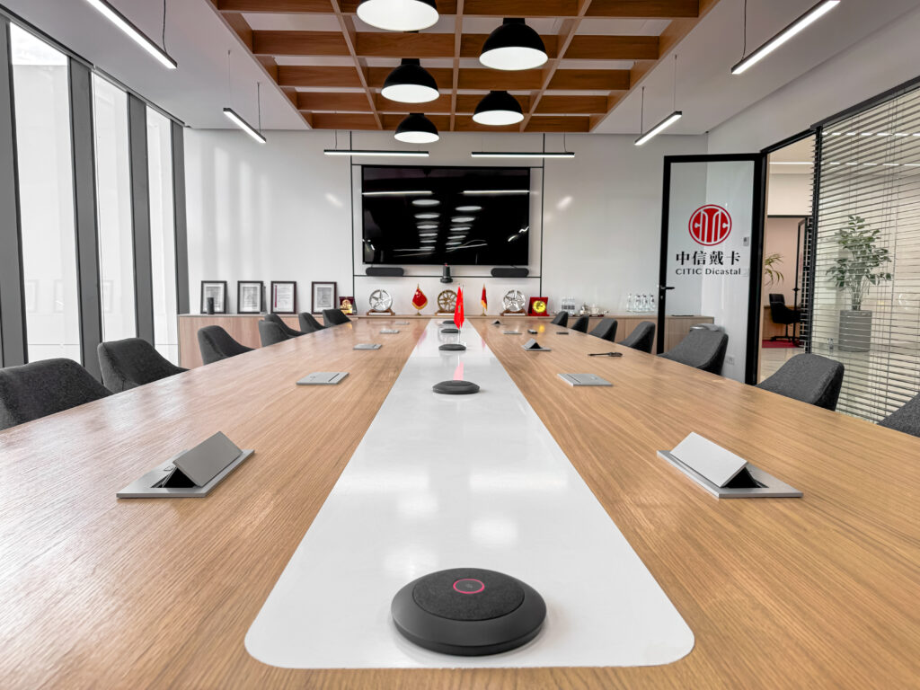 Salle de réunion professionnelle avec mobilier en bois clair et éclairage LED intégré.